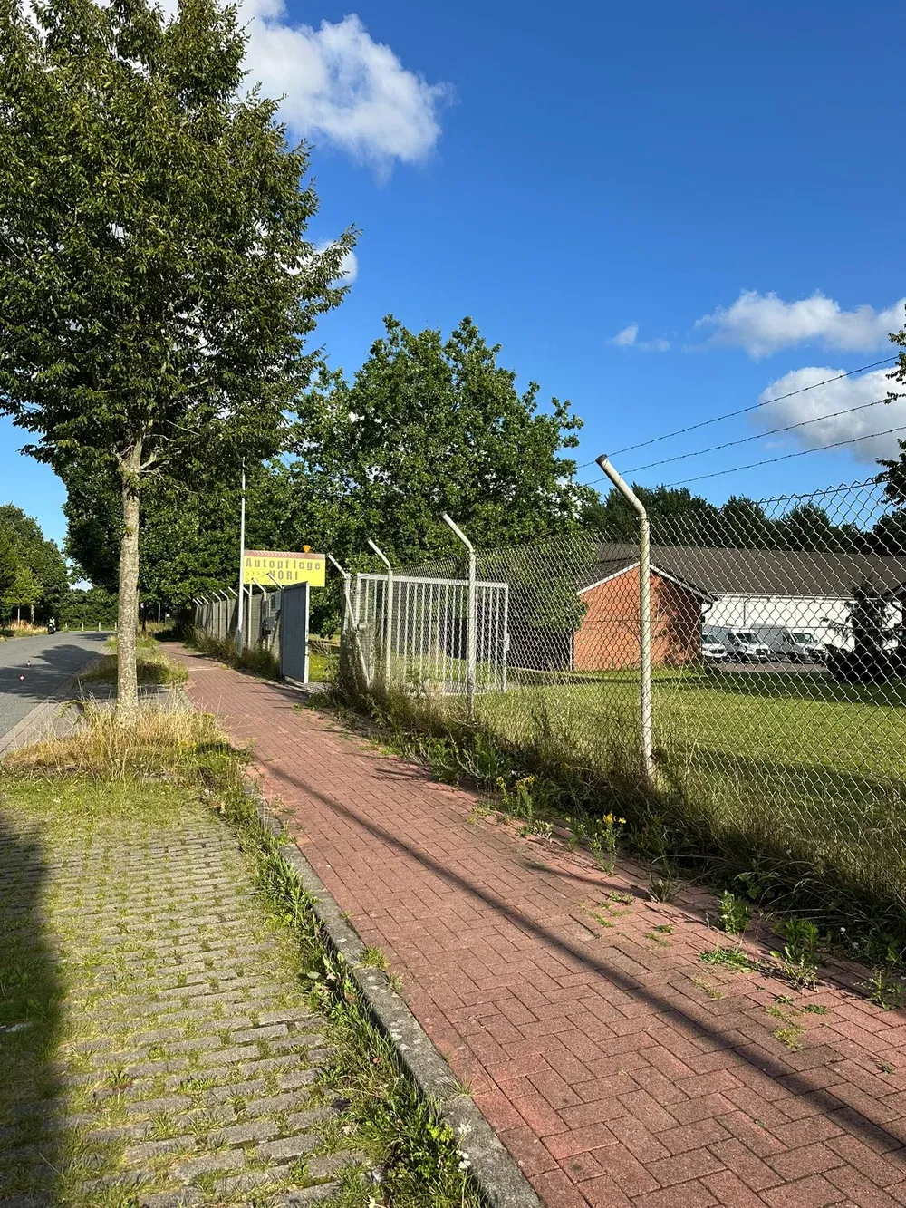 Zufahrt zu Autopflege NORI mit gelbem Hinweisschild an der Schanzenstraße
